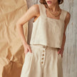 FJØRNA square neck linen cropped tank top displayed on a hanger, showcasing its lightweight, breathable fabric and stylish design.