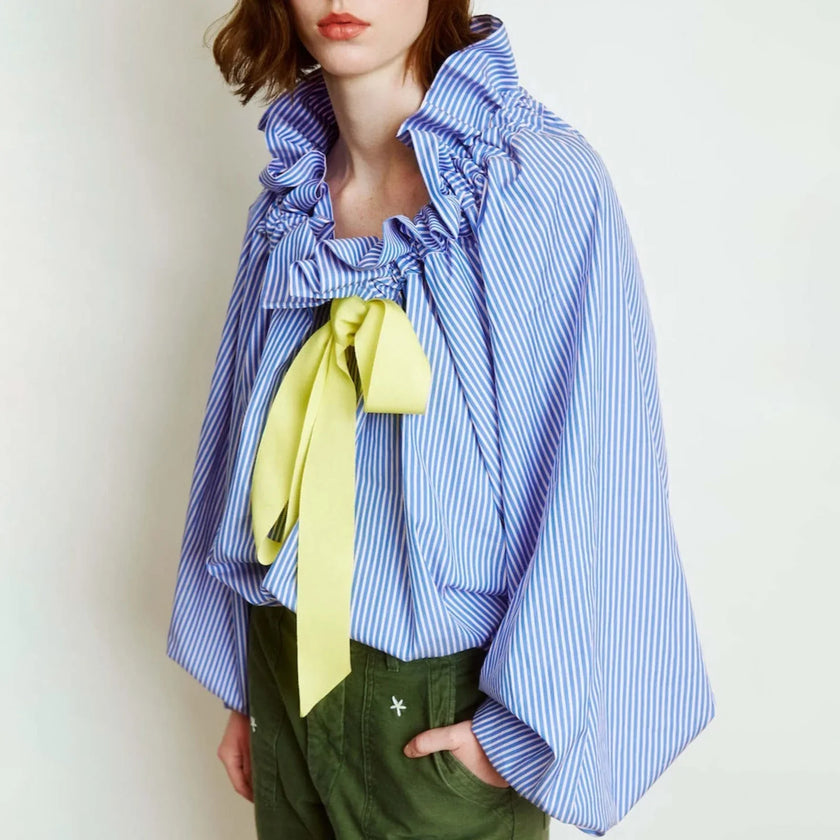 FJØRNA women's cotton blouse with ruffle detail, showcasing lightweight, stylish top with feminine design and soft fabric.