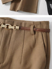 Women’s wool wide-leg trousers by FJØRNA, high waist and tailored fit, shown on a model in a stylish outdoor setting.