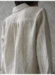 FJØRNA women's linen pleated shirt, light and breathable top with a relaxed fit and classic collar, shown in natural fabric texture.
