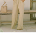 FJØRNA women's linen wide-leg trousers with elastic waist and ruffle detail, displayed on a model.