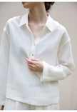FJØRNA women's linen polo top with collar, lightweight and breathable, shown in a close-up of the shirt's collar and fabric texture.