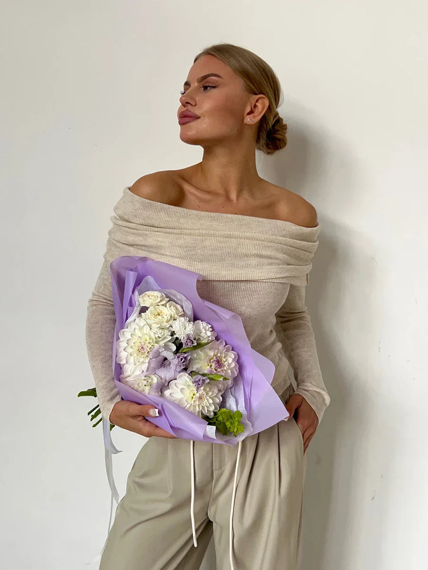 Off-shoulder ribbed knit top for women by FJØRNA, featuring a fitted style and textured fabric.