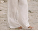 FJØRNA women's linen top with ruffle detail, featuring a lightweight, breathable fabric and feminine design.