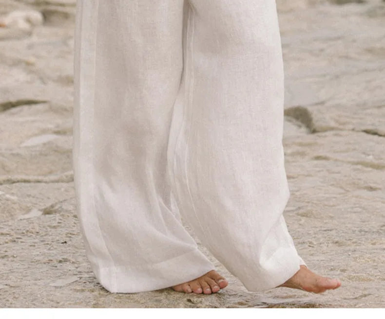 Women's linen wide-leg trousers with elastic waist and ruffle details by FJØRNA, shown in a relaxed fit style.