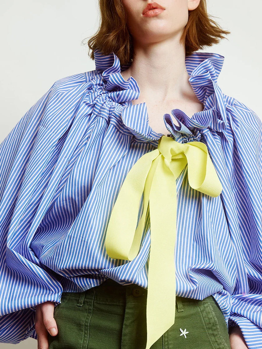 FJØRNA women's cotton blouse with ruffle detail, long sleeves and classic design, featuring a soft and breathable fabric.