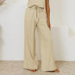 FJØRNA linen wide-leg trousers for women with elastic waist and ruffle details, showcasing a relaxed fit and lightweight fabric.
