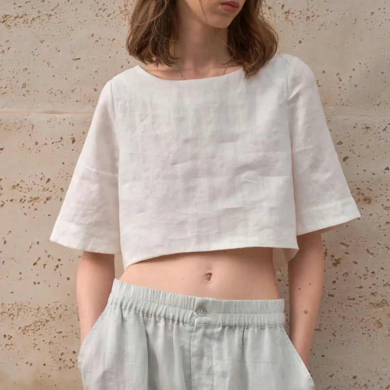 FJØRNA women's linen crop top with short sleeves, lightweight and breathable, shown in a natural relaxed fit.