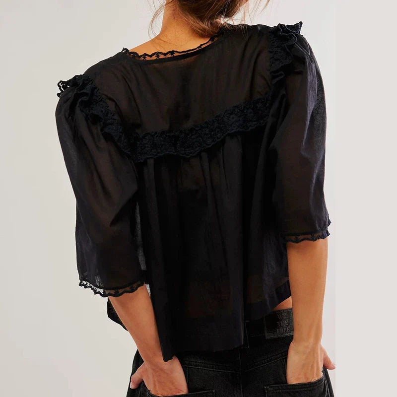 FJØRNA women's cotton blouse with ruffle detail, showcasing a stylish and lightweight top with feminine design and soft fabric.