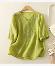 FJØRNA women's cotton V-neck blouse featuring a classic design and soft fabric, displayed on a mannequin.
