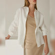 FJØRNA linen shirt with slit hem detail, lightweight and breathable, shown on a model in a casual outdoor setting