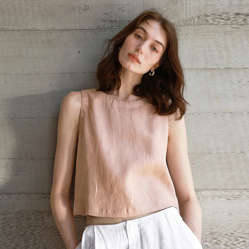 FJØRNA women's linen crop top, lightweight and breathable, shown in a natural pose highlighting the sleeveless design.