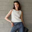 FJØRNA women's linen crop top, lightweight and breathable, shown in natural beige with short sleeves and a relaxed fit.