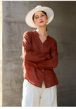 FJØRNA women's linen V-neck shirt, lightweight and breathable top with long sleeves and relaxed fit, shown in natural fabric texture.