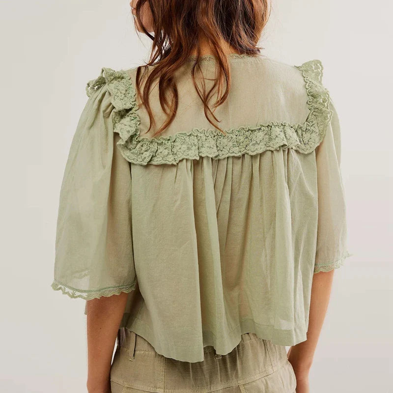 FJØRNA women's cotton blouse with ruffle details, showcasing a stylish, lightweight top with feminine design and soft fabric.