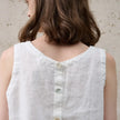FJØRNA women's linen crop top, sleeveless and breathable, shown in natural fabric with a relaxed fit and stylish design.