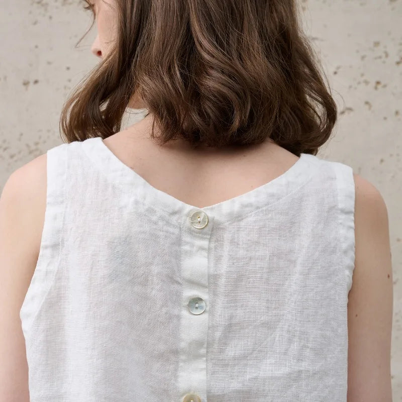 FJØRNA women's linen crop top, sleeveless and breathable, shown in natural fabric with a relaxed fit and stylish design.