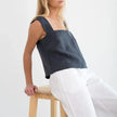 FJØRNA square neck linen cropped tank top displayed on a hanger, showcasing its lightweight, breathable fabric and modern design.