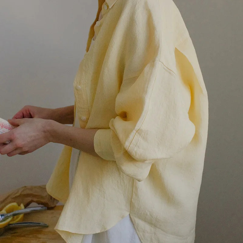 FJØRNA linen shirt with slit hem detail, lightweight and breathable, shown on a model in a casual outdoor setting