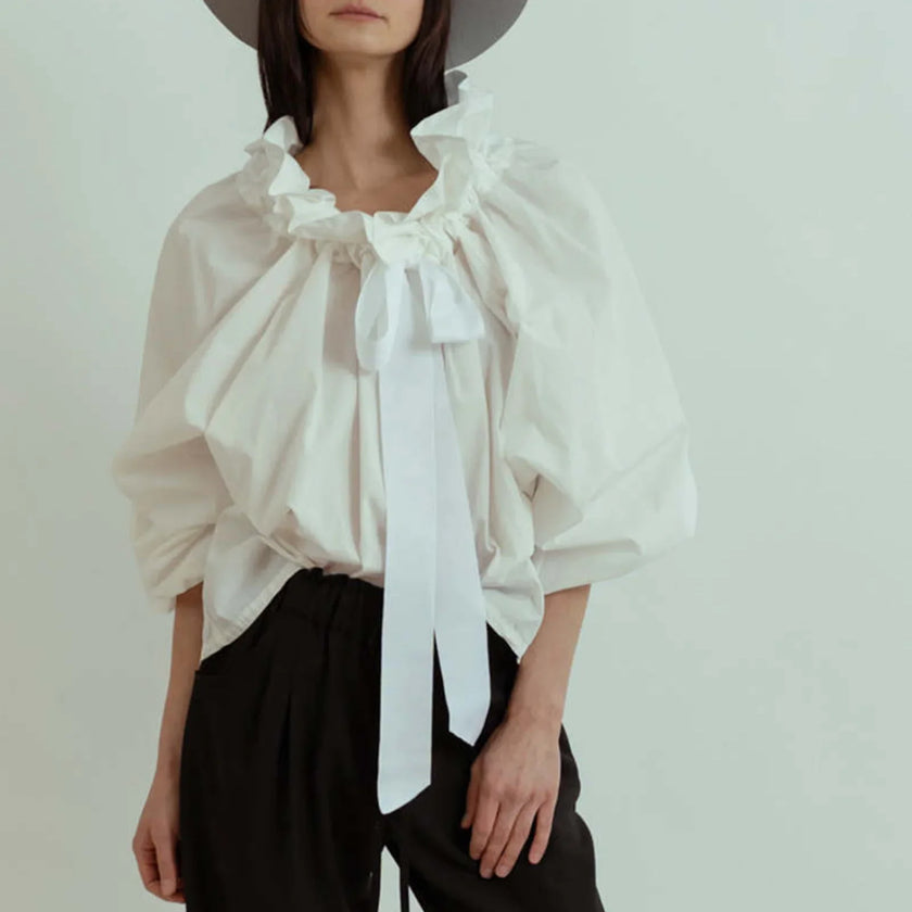 FJØRNA women's cotton blouse with ruffle detail, featuring a stylish and comfortable top for women.