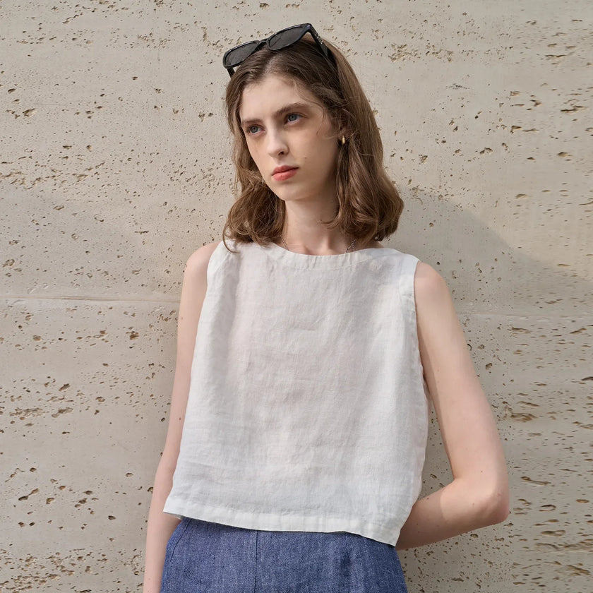 FJØRNA women's sleeveless linen crop top with a relaxed fit and stylish design, perfect for casual summer wear.