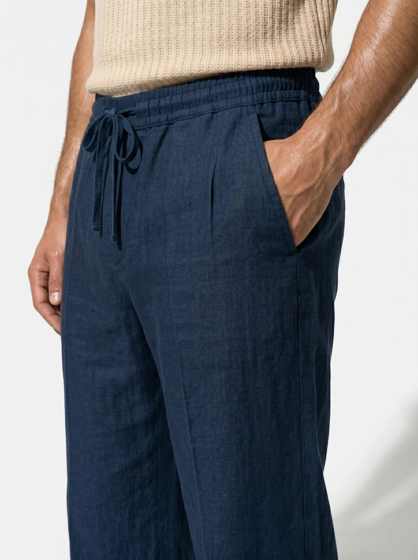 Men's linen trousers by FJØRNA with relaxed fit, breathable fabric, ideal for summer, shown in a close-up shot.