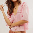 FJØRNA women's cotton blouse with ruffle detail, showcasing a stylish, lightweight top with feminine design and soft fabric.