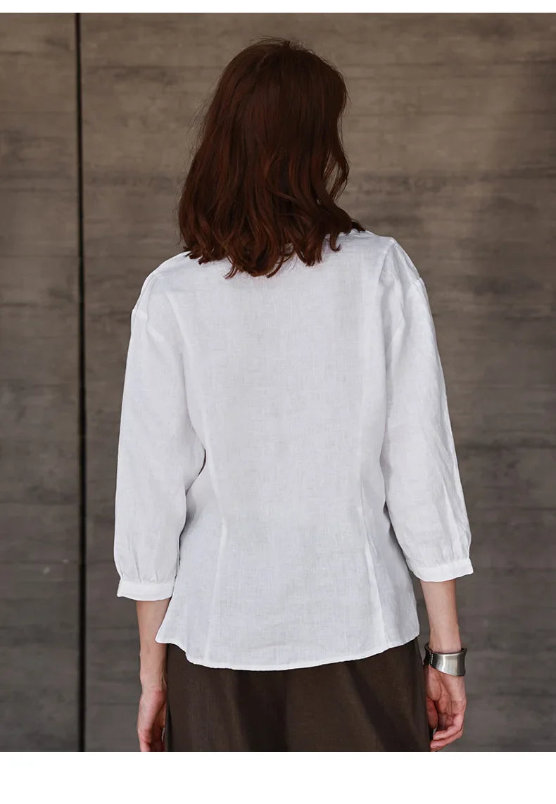 FJØRNA tailored V-neck linen top in neutral color, close-up of soft fabric and stylish fit for casual or summer wear.