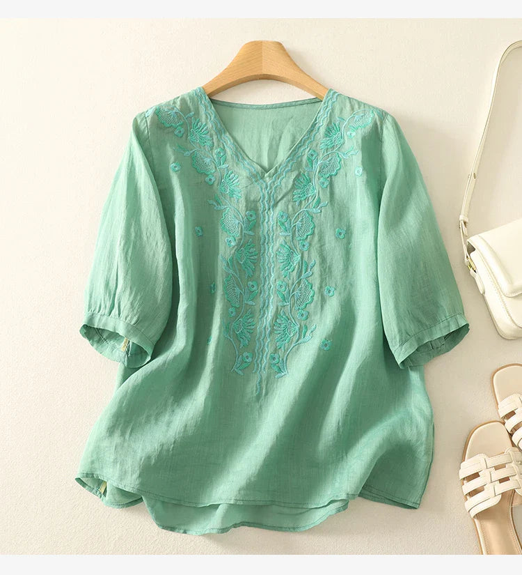 FJØRNA women's cotton V-neck blouse with long sleeves, featuring a relaxed fit and soft fabric, displayed on a mannequin.
