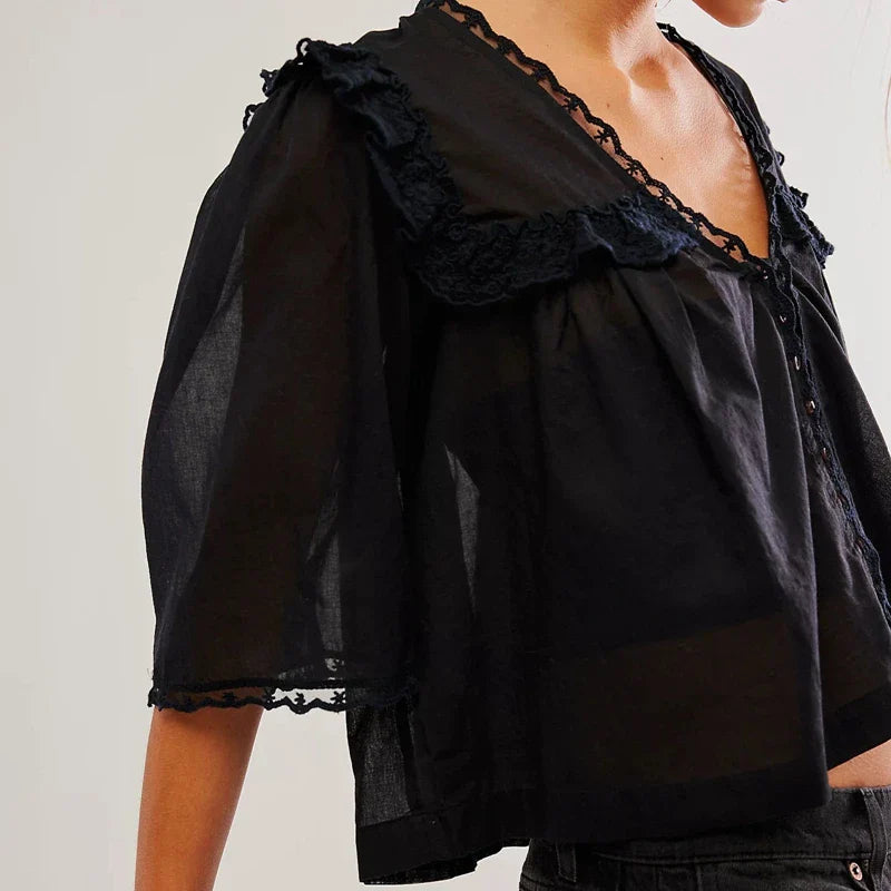 FJØRNA women's cotton blouse with ruffle detail, featuring a stylish and comfortable top with delicate ruffle accents.