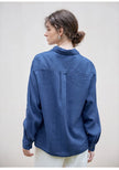 FJØRNA linen blend women's shirt, lightweight and breathable top with a relaxed fit, shown in natural fabric texture.