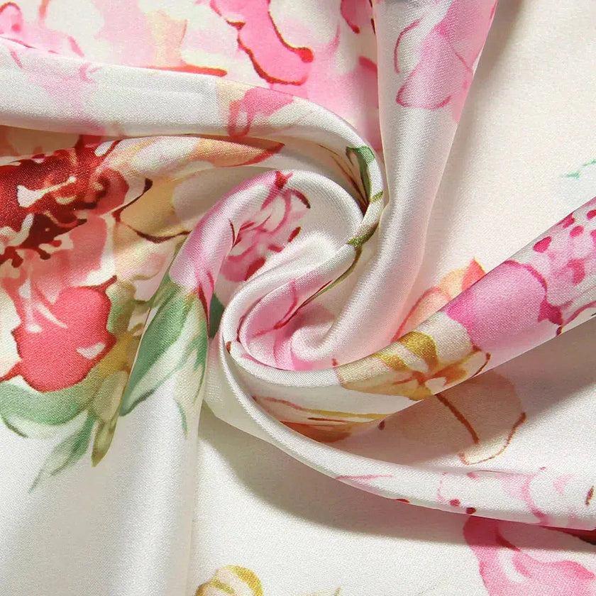 White satin floral pencil maxi dress by FJØRNA with a fitted silhouette and elegant floral pattern.