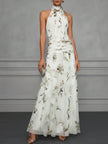 FJØRNA Jasmine floral halter wedding guest dress with a fitted bodice and flowy skirt, featuring a vibrant floral pattern.