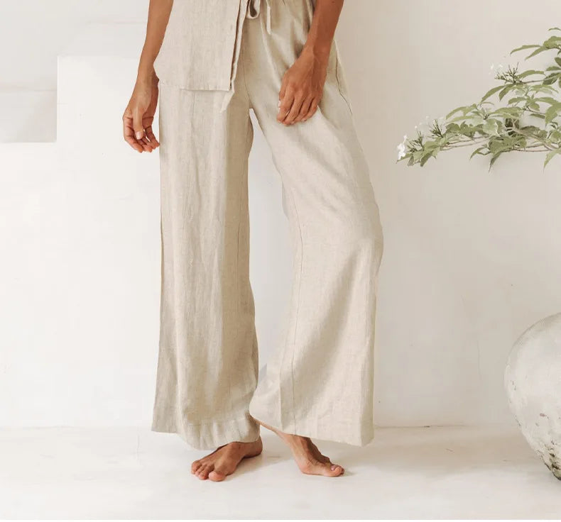 FJØRNA linen wide-leg women's trousers with elastic waist and ruffle detail, stylish and comfortable for casual wear.