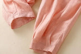 FJØRNA linen tapered women's trousers showing a relaxed fit, high waist, and light, breathable fabric in natural linen color.