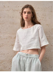 FJØRNA linen crop top for women with short sleeves, lightweight and breathable fabric, casual style, shown on a model.