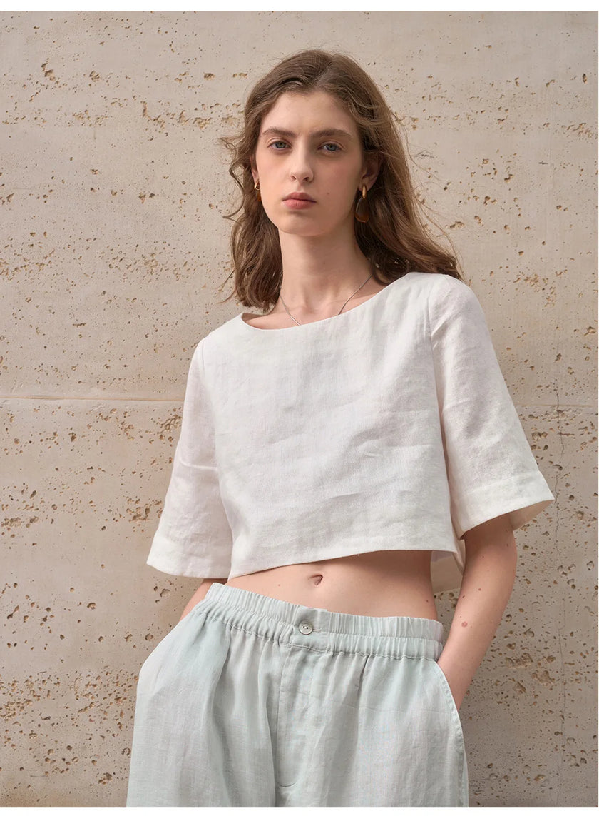 FJØRNA linen crop top for women with short sleeves, lightweight and breathable fabric, casual style, shown on a model.
