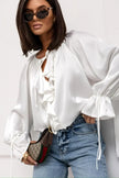 FJØRNA satin women's blouse with ruffle detail, stylish top featuring elegant fabric and feminine design.