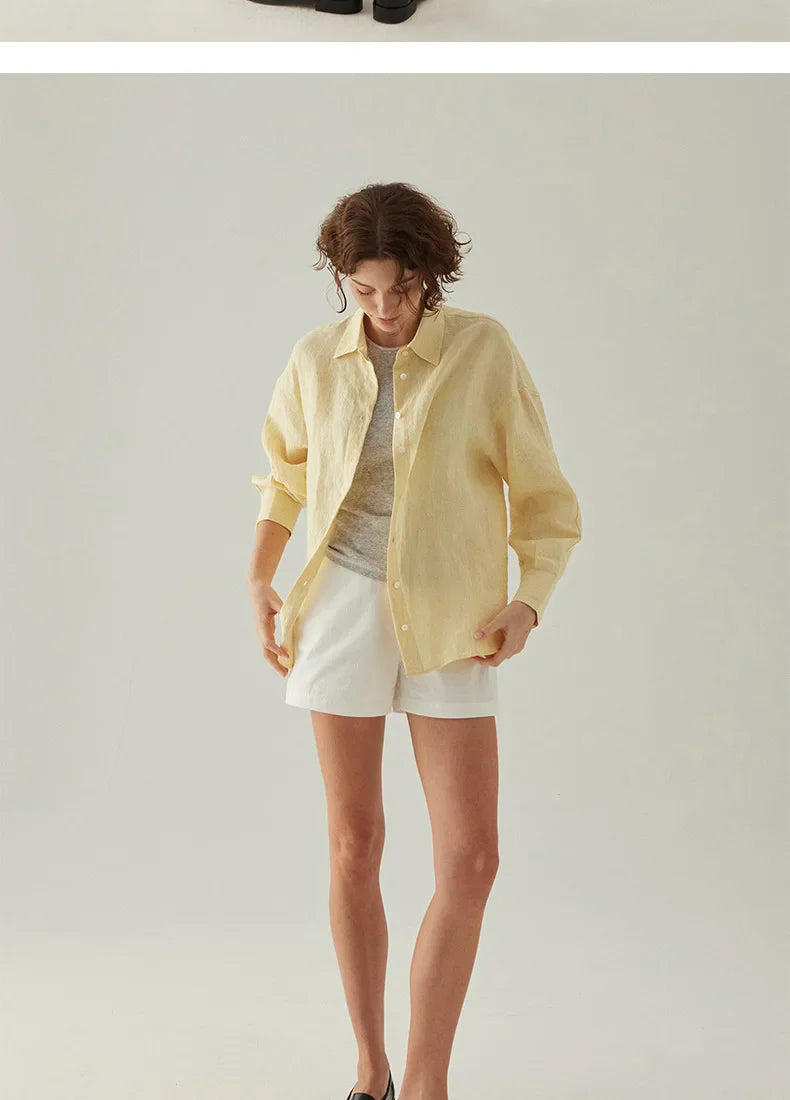 FJØRNA linen shirt with slit hem detail, lightweight and breathable, shown on a model in a casual outdoor setting