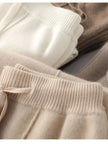 FJØRNA women's merino wool wide-leg high-waist trousers, close-up of soft, textured fabric and tailored fit.
