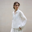 Women's linen polo top with collar by FJØRNA, shown in a close-up of the soft, lightweight fabric and classic neckline.