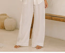 FJØRNA women’s linen wide-leg trousers with elastic waistband and ruffle detail, showcasing a relaxed fit and lightweight fabric.