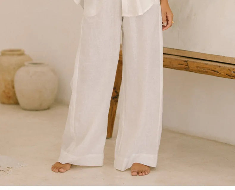 FJØRNA women’s linen wide-leg trousers with elastic waistband and ruffle detail, showcasing a relaxed fit and lightweight fabric.
