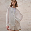Light beige linen shirt for women by FJØRNA, featuring a relaxed fit and classic collar, perfect for casual or office wear.