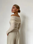 Off-shoulder ribbed knit top for women by FJØRNA, featuring a fitted design and textured fabric in neutral color.