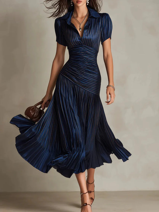 FJØRNA Zaffira white pleated midi dress shown on a model, featuring a flowy, elegant design with a fitted waist and midi length.