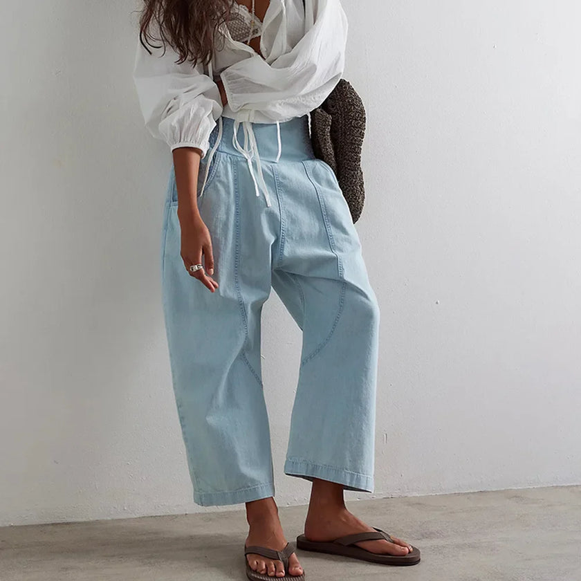 Women’s wide-leg denim trousers by FJØRNA, showcasing relaxed fit and classic blue denim fabric with side pockets.