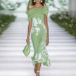 FJØRNA fitted off-shoulder mermaid midi dress with draped neckline and floral pattern, showcasing elegant design and form-fitting style.