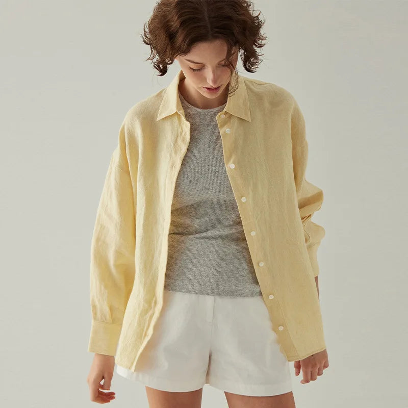 FJØRNA linen shirt featuring a slit hem detail, lightweight and breathable with a relaxed fit, shown on a model.
