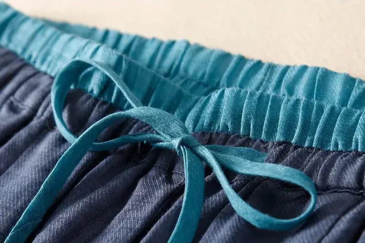 FJØRNA linen tapered women's trousers, lightweight and breathable, shown in a relaxed fit with a neutral color.